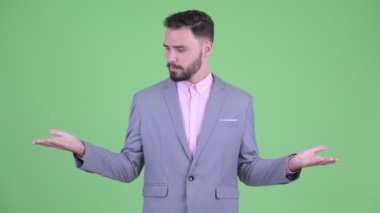 Mutlu genç sakallı işadamı bir şey karşılaştırarak