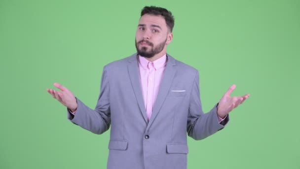Confused young bearded businessman shrugging shoulders — Stock Video