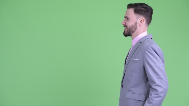 Vista de perfil de feliz joven barbudo hombre de negocios sonriendo — Vídeos de Stock