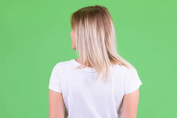 Pohled na mladou blonďatou ženu, jak se dívá přes rameno — Stock fotografie