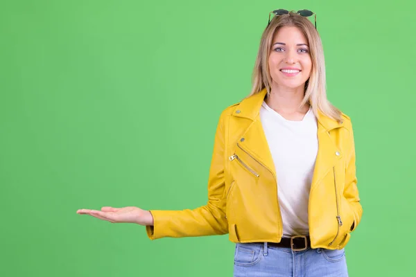 Felice giovane donna bionda ribelle mostrando qualcosa — Foto Stock