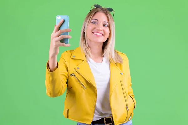 Happy young rebellious blonde woman taking selfie — Stock Photo, Image