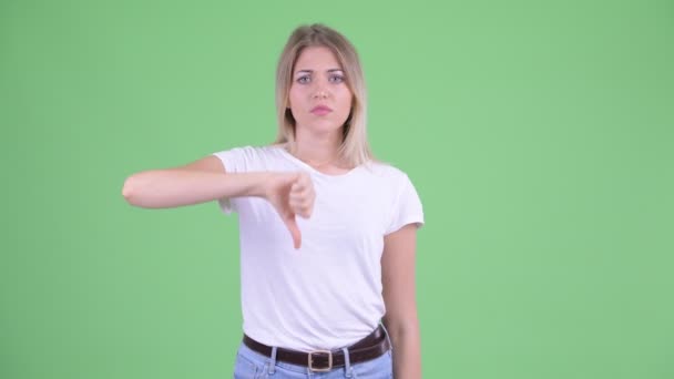 Üzgün genç sarışın kadın başparmak aşağı veren — Stok video