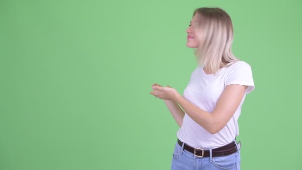 Boldog fiatal gyönyörű szőke nő mutatja, hogy a hátsó — Stock videók