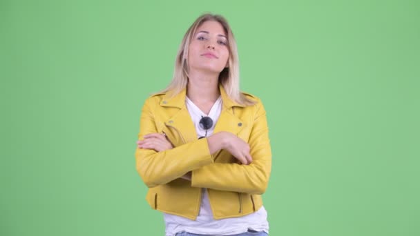 Feliz joven rebelde rubia sonriendo con los brazos cruzados — Vídeos de Stock