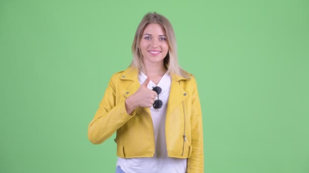 Happy young rebellious blonde woman giving thumbs up — Stock Video