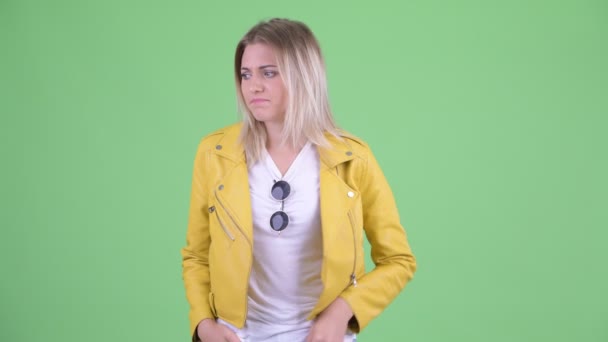Betonade unga rebelliska blonda kvinnan pratar och ser ledsen — Stockvideo