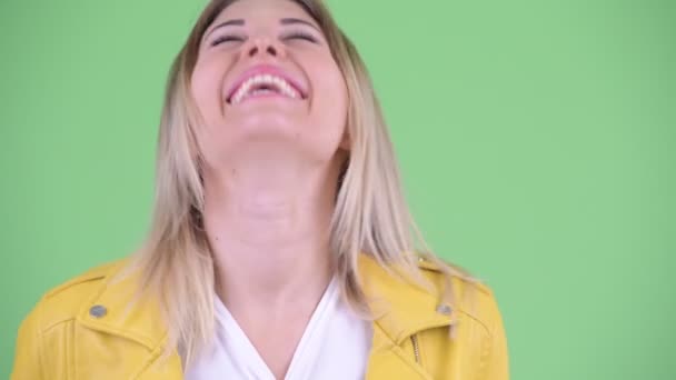 Лицо счастливой молодой бунтарской блондинки, улыбающейся и смеющейся — стоковое видео