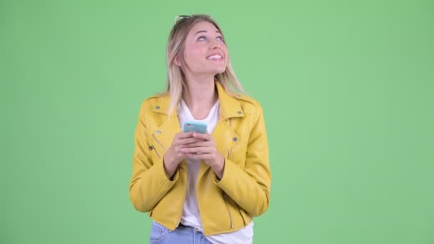 Szczęśliwy młody zbuntowny blond kobieta myślenia podczas korzystania z telefonu — Wideo stockowe