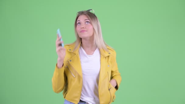전화에 말하는 행복한 젊은 반항적 인 금발의 여자 — 비디오