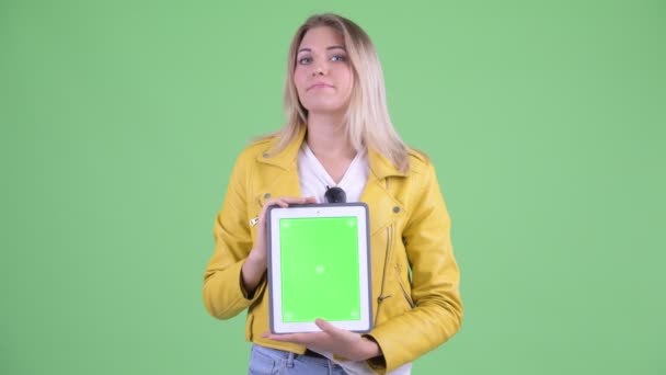 Mujer rubia rebelde joven estresada mostrando tableta digital — Vídeos de Stock
