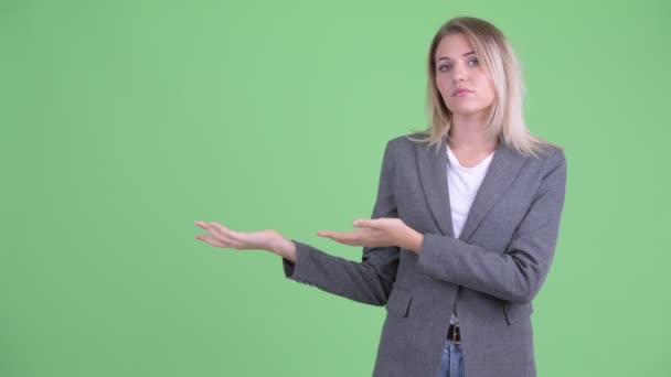 Mujer de negocios rubia joven estresada mostrando algo — Vídeos de Stock