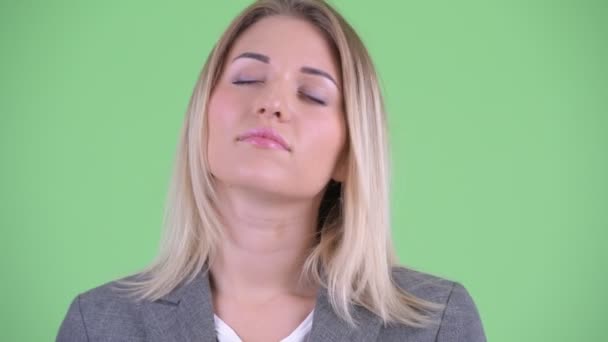 Face of happy young blonde businesswoman relaxing with eyes closed — Stock Video