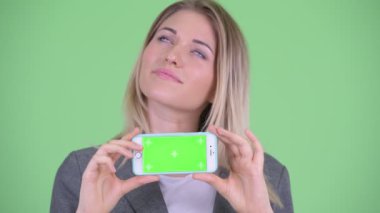 Telefon gösterilen süre düşünerek mutlu genç sarışın iş kadını yüzü