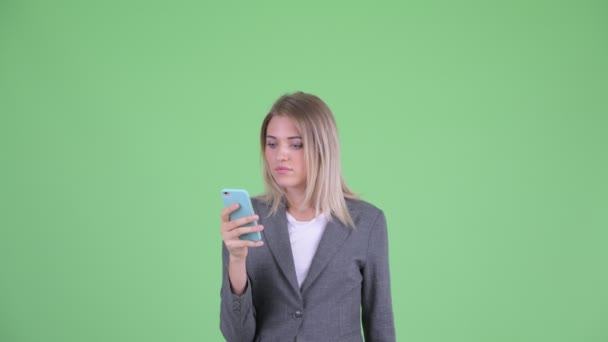Πρόσωπο της ευτυχισμένο νεαρό ξανθιά επιχειρηματίας χρησιμοποιώντας το τηλέφωνο και αναζητούν έκπληκτος — Αρχείο Βίντεο
