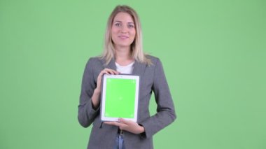 Mutlu genç sarışın iş kadını dijital tablet gösterirken konuşuyor
