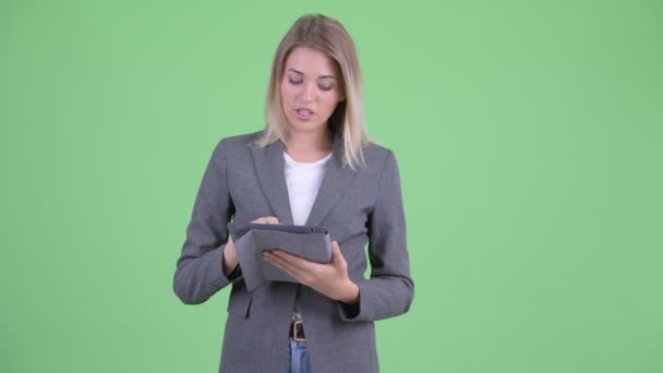 Heureuse jeune femme d'affaires blonde présentant avec tablette numérique — Video