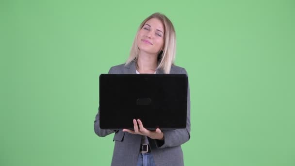 Щаслива молода блондинка бізнес-леді думає під час використання ноутбука — стокове відео