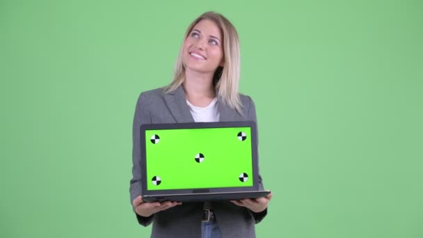 Šťastné mladé blond podnikatelka myšlení při zobrazování laptop — Stock video