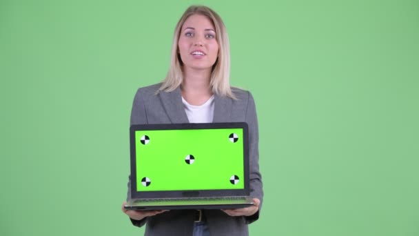 Ευτυχής νεαρή ξανθιά επιχειρηματίας μιλάει ενώ δείχνει το laptop — Αρχείο Βίντεο