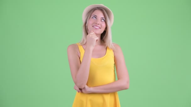 Счастливая молодая блондинка туристка думает и смотрит вверх — стоковое видео
