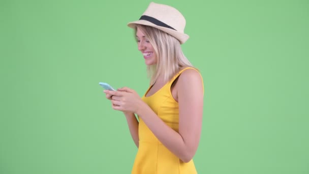 Profilnézet a fiatal szőke turista nő a telefon, hogy elvitték — Stock videók