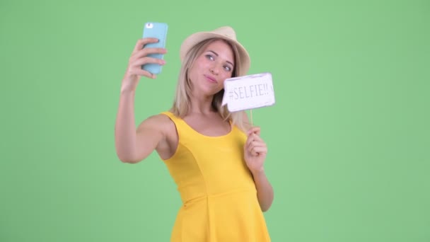 Feliz jovem loira turista mulher tomando selfie com sinal de papel — Vídeo de Stock