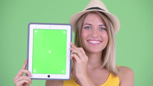 Gezicht van Happy Young blonde toeristische vrouw toont digitale Tablet — Stockvideo