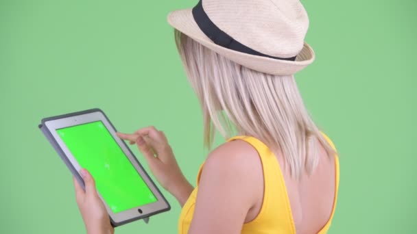 Zbliżenie widok z tyłu szczęśliwy młody blond kobieta turysta za pomocą cyfrowego tabletu — Wideo stockowe
