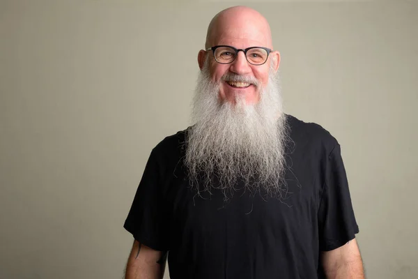 Homem careca maduro feliz com longa barba cinza sorrindo e vestindo óculos — Fotografia de Stock