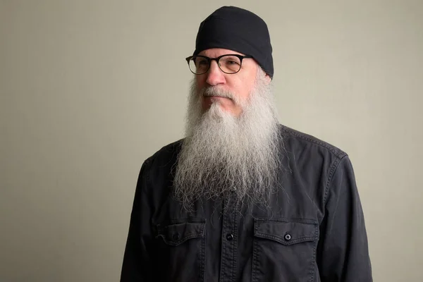 Зрелый мужчина с длинной седой бородой думает и носит очки — стоковое фото