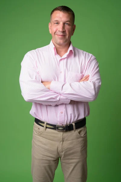 Happy mature macho businessman smiling with arms crossed — Stock Photo, Image