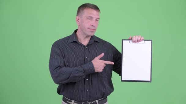 Macho volwassen zakenman toont Klembord en geeft duimen omhoog — Stockvideo