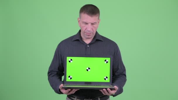 Boze macho volwassen zakenman toont laptop — Stockvideo