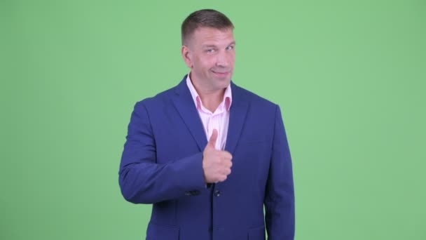 Счастливый зрелый мачо-бизнесмен в костюме показывает большие пальцы вверх — стоковое видео