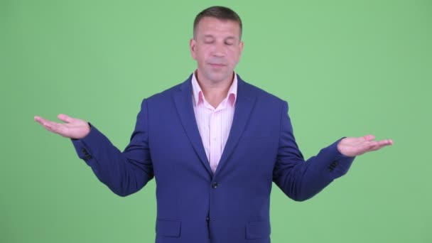 Volwassen macho zakenman in pak iets vergelijken — Stockvideo
