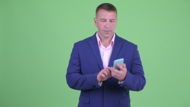 Volwassen macho zakenman in pak toont stop gebaar tijdens het praten over de telefoon — Stockvideo