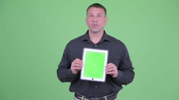 Macho mogen affärsman pratar medan du visar Digital Tablet — Stockvideo