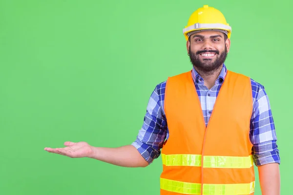 Щасливий молодий надмірна вага бородатий Індійська людина будівельний працівник показує щось — стокове фото