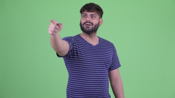 Happy young overweight bearded Indian man pointing finger — Stock Video