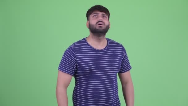 Stressed young overweight bearded Indian man looking around and feeling upset — Stock Video