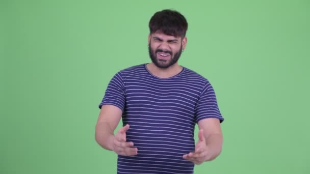 Heureux jeune homme indien barbu en surpoids parler et regarder excité — Video