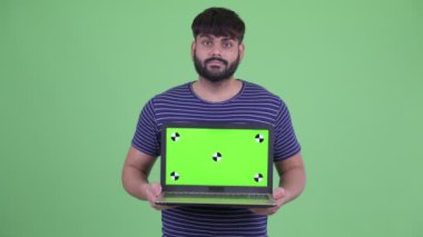 Mutlu genç kilolu sakallı Hintli adam dizüstü gösteren