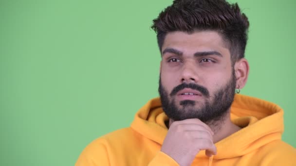 Gesicht eines glücklichen jungen, übergewichtigen, bärtigen indischen Mannes, der nachdenkt und aufblickt — Stockvideo