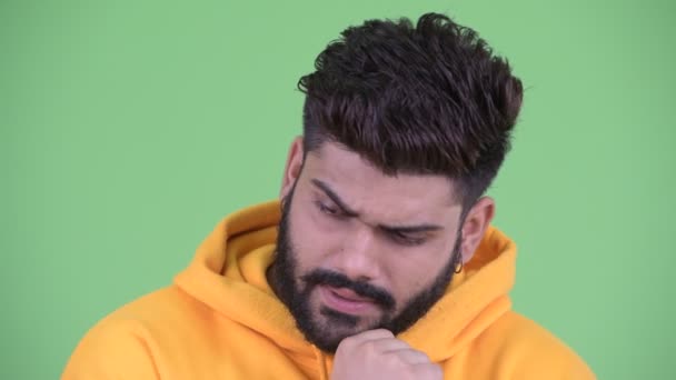 Лицо напряженного молодого толстого бородатого индийца, думающего и смотрящего вниз — стоковое видео