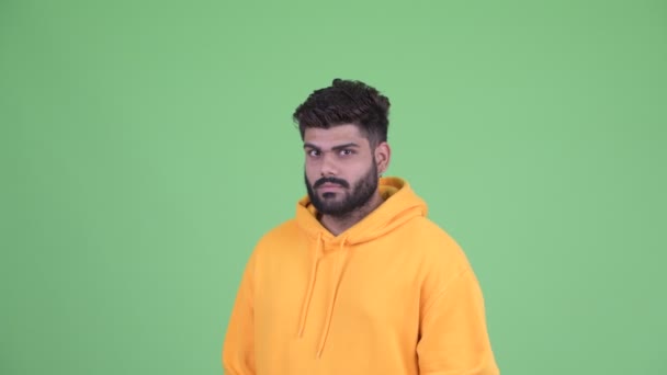 Gesicht eines lustigen jungen, übergewichtigen, bärtigen indischen Mannes mit dem Finger auf dem Kopf — Stockvideo