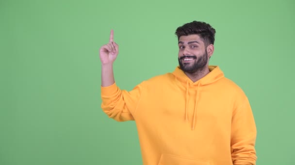 Happy young overweight bearded Indian man thinking and pointing up — Stock Video