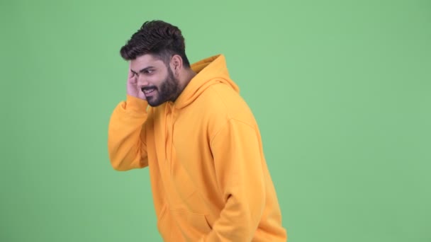 Happy young overweight bearded Indian man listening and getting good news — Stock Video