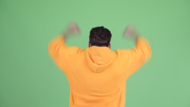 Widok z tyłu szczęśliwego młodego nadwagą Brodaty Indyjski człowiek z pięści podniesione — Wideo stockowe