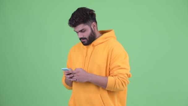 Szczęśliwy młody nadwaga Brodaty Indyjski człowiek za pomocą telefonu i uzyskiwanie dobrych wiadomości — Wideo stockowe
